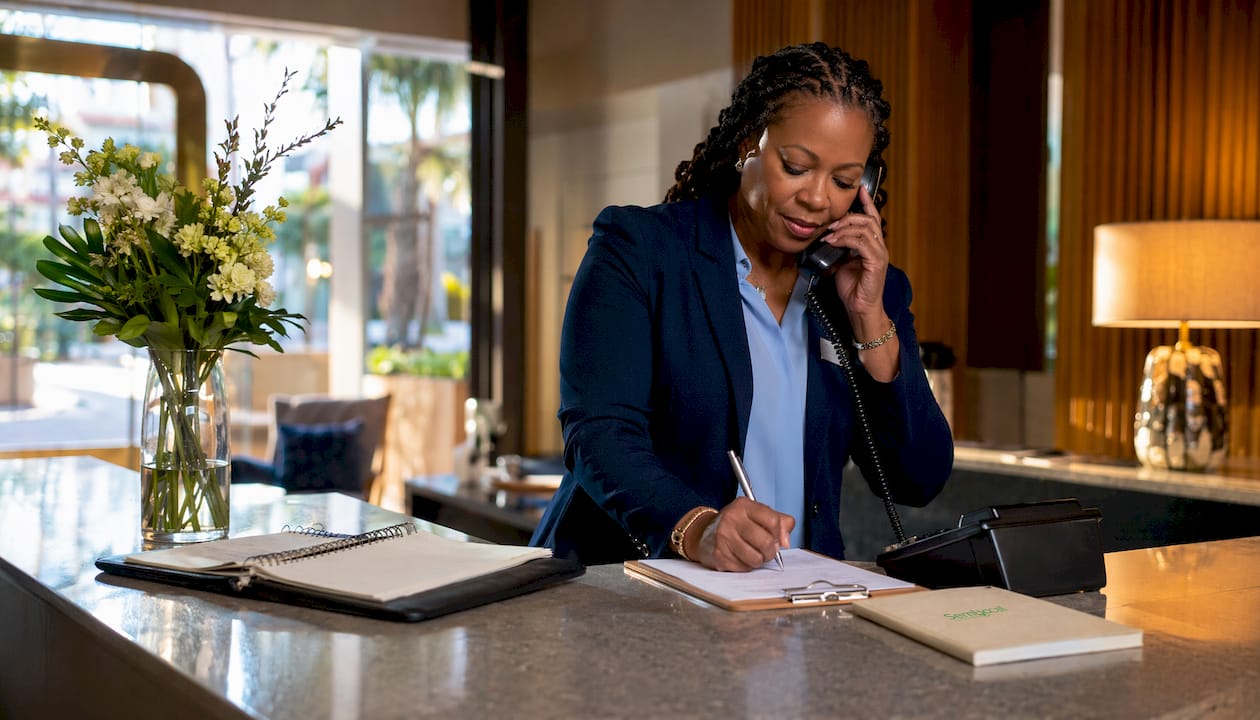 Hotel manager using phone at front desk