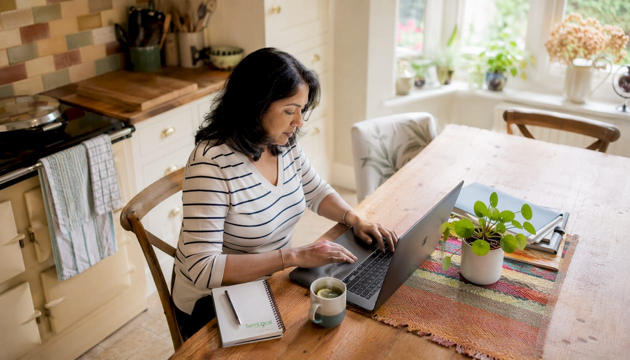 Woman replying to Google reviews on laptop