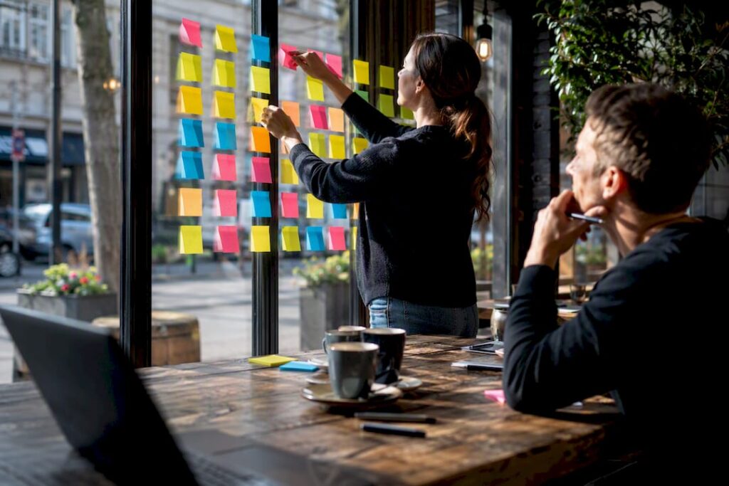 Hands arranging lead qualification notes on board