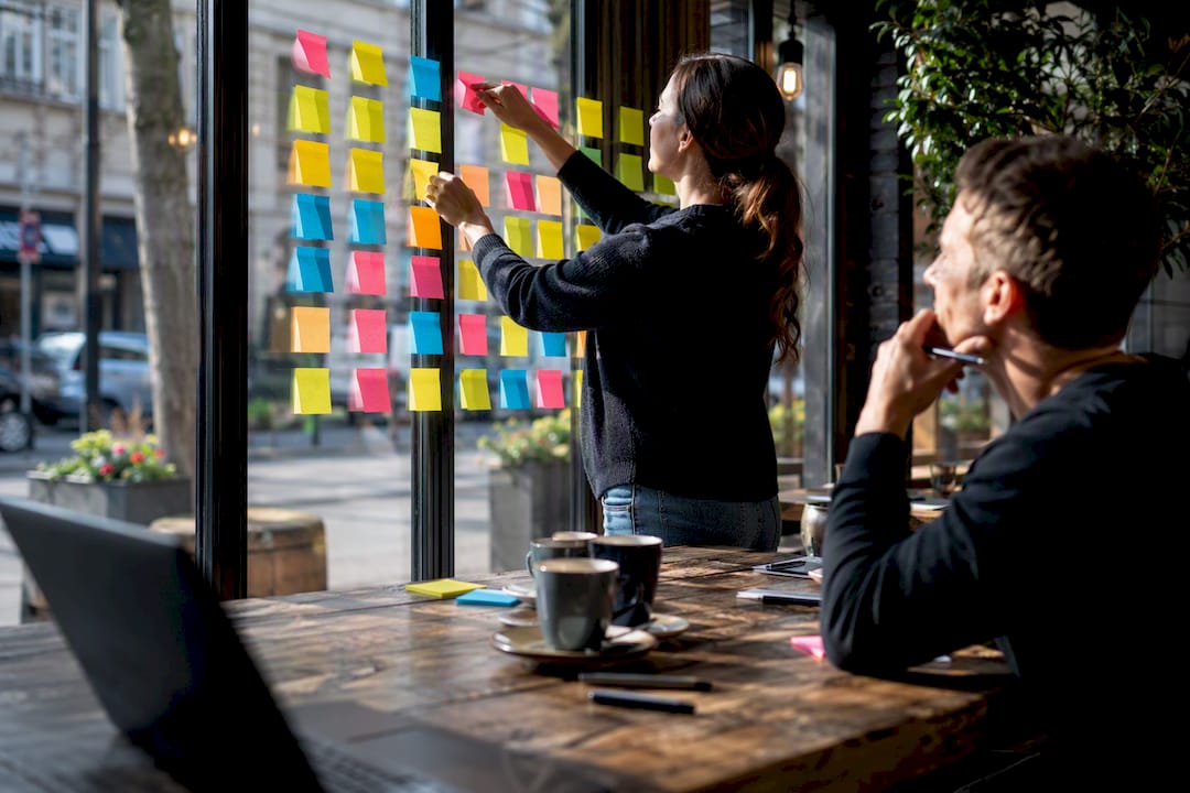 Hands arranging lead qualification notes on board
