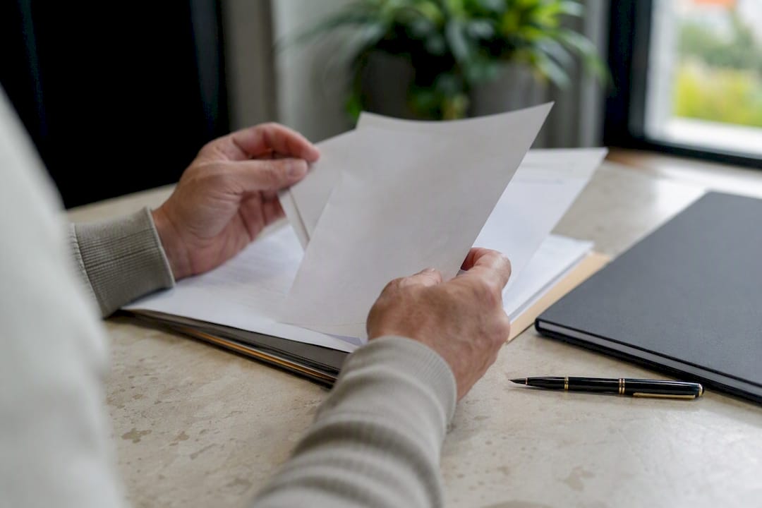 Hands holding business verification papers